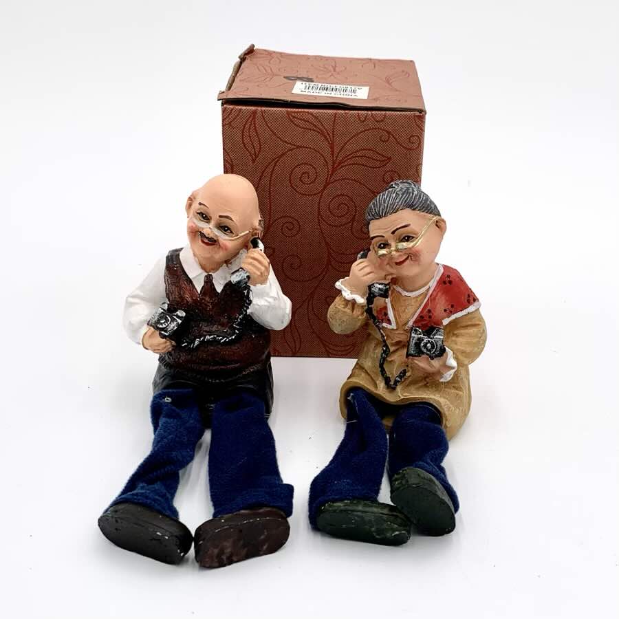 Granpa and Grandma on the phone legs handing decorative piece - FD817V